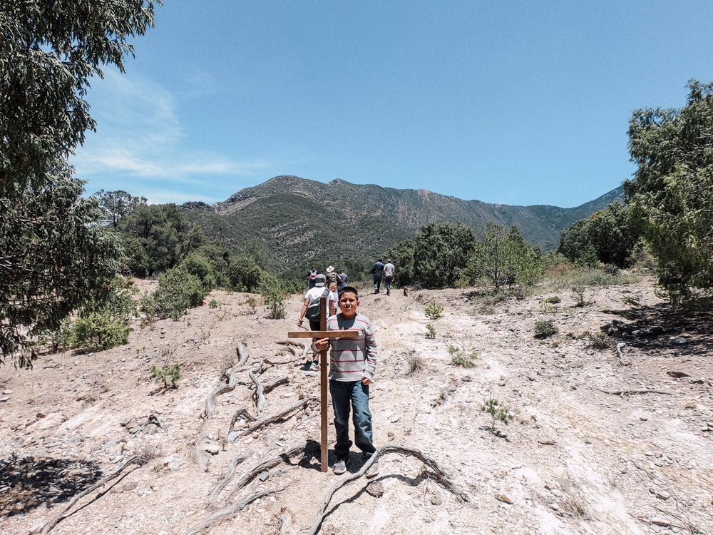 Missionaries and Mexican Youth hikin into the mountains carrying a large cross